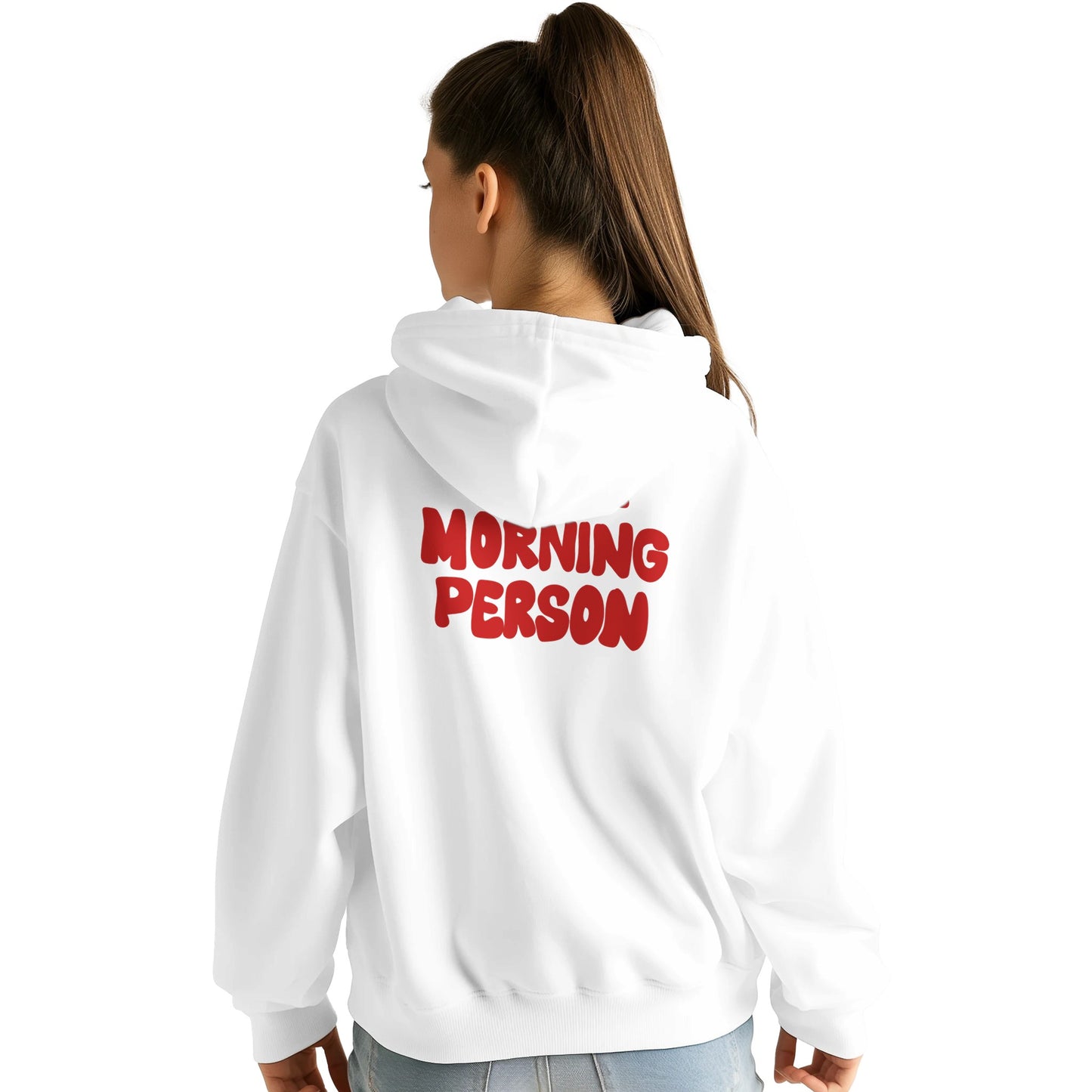 A young woman wearing a white hoodie with the phrase "MORNING PERSON" printed in bold red letters on the back. The hoodie has a relaxed fit, a large hood, and long sleeves. She is standing with her back to the camera, her head slightly turned to the side, showcasing the design against a plain white background.
