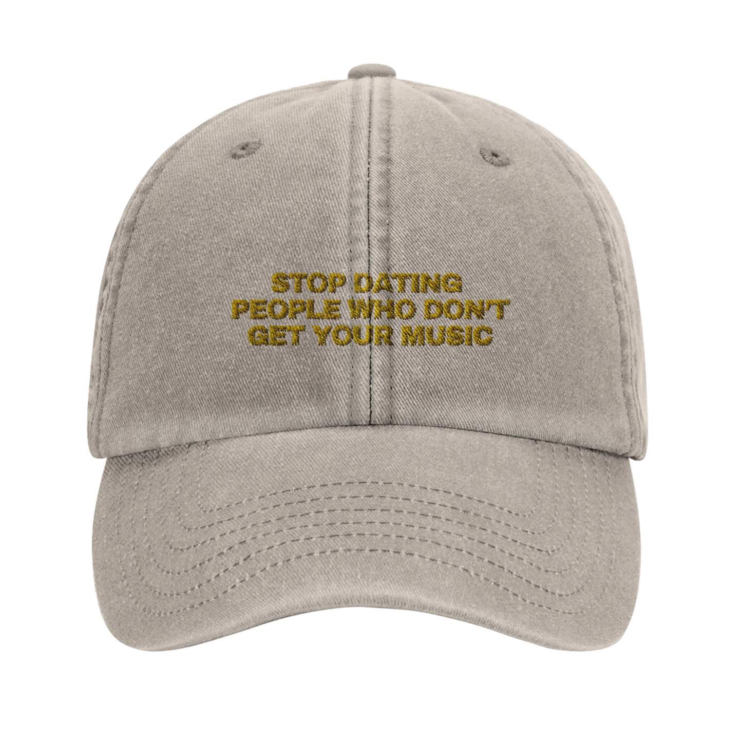 Beige baseball cap with yellow gold embroidery that reads 'Stop Dating People Who Don’t Get Your Music', shown from the front. Casual unisex design. Viral statement.